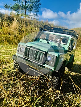 Green sport utility car on off road near the bushes