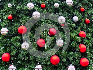 Green spruce branches with red matte and silver mirror balls and small blue lights from a garland