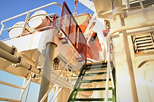 Green stairs with red protection metal security grill on top against piracy attack on container vessel.