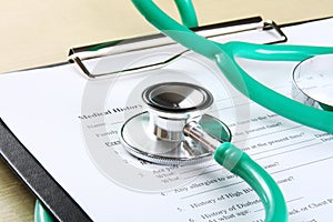 Green stethoscope lying on a medical record