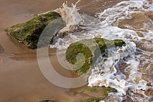 The green stones in the ocean wave