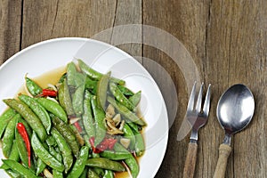 Green string bean fried oyster sauce of Thai foods on wooden floor
