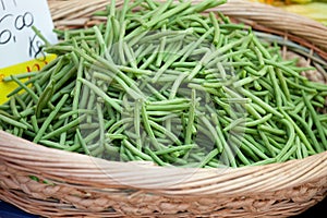 Green string beans in woven basket close-up