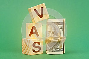 On a green surface, dollars and cubes with the inscription - VAS