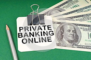 On a green surface, a pen, dollars and paper with the inscription - Private banking online