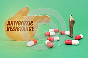 On the green surface of the tablet, the figure of a man and a hand with the inscription - ANTIBIOTIC RESISTANCE