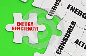 On a green surface are white puzzles with text, on a separate puzzle there is an inscription - Energy Efficiency