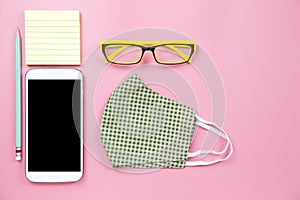 Green surgical mask plaid and yellow glasses with pencil mobile clipping path screenon pink backgroud pastel style flatlay topview
