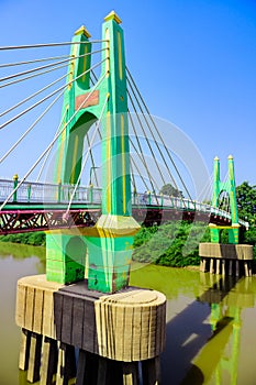 Green suspension bridge across Nan River at Chum Saeng District