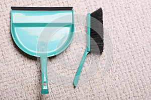 Green sweeping brush and dustpan on floor - housework