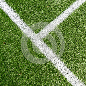 Green synthetic artificial grass soccer sports field with white corner stripe line