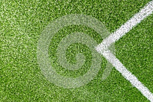 Green synthetic artificial grass soccer sports field with white corner stripe line