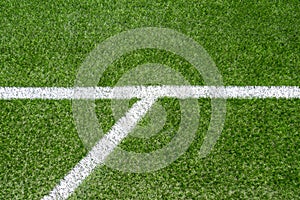 Green synthetic artificial grass soccer sports field with white corner stripe line