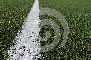 Green synthetic artificial grass soccer sports field with white corner stripe line