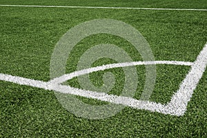 Green synthetic artificial grass soccer sports field with white corner stripe line