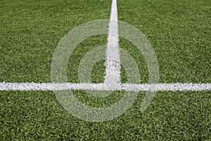 Green synthetic artificial grass soccer sports field with white stripe lines