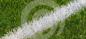 Green synthetic grass soccer sports field with white stripe line
