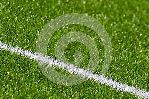 Green synthetic grass soccer sports field with white stripe line