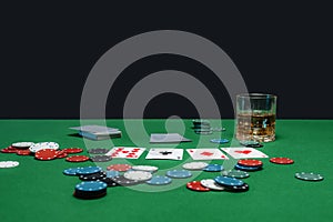 Green table in casino with poker cards and chips