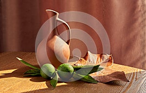 green tangerines and clay jug