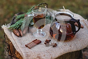 Green tea beautifully brewed in a glass teapot outdoors in the forestBlack