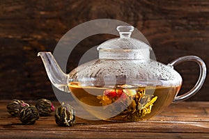 Green tea. Blooming flower in glass teapot