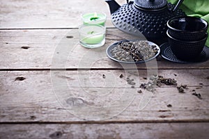 Green tea in bowl and traditional asian tea set on aged wooden