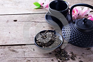 Green tea in bowl and traditional asian tea set on aged wooden