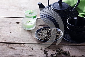 Green tea in bowl and traditional asian tea set on aged wooden