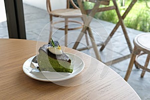Green tea cheesecake - A plate of homemade matcha cheesecake topped with whipped cream cheese on table background. Japanese Matcha