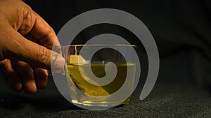 Green tea in a glass cup on a dark background. Closeup