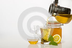 Green tea in glass cups with honey and lemon on white backgroundea photo