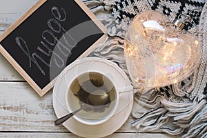 Green tea, heart shaped lantern, knitted blanket and blackboard with text hygge