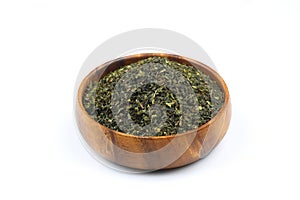 Green tea with herbs in wooden bowl on a White Background