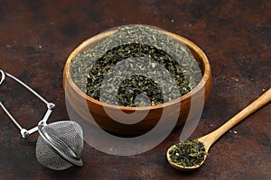 Green tea with herbs in wooden bowl on a wooden board