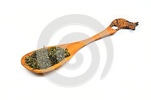 Green tea with herbs in wooden spoons on a White Background