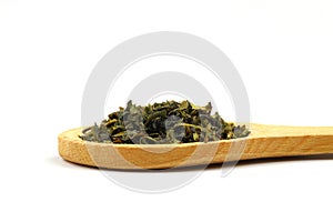 Green tea with herbs in wooden spoons on a White Background