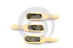 Green tea with herbs in wooden spoons on a White Background