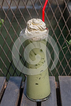 Green tea iced with whipped cream set on the table ready to serve.