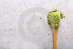 Green tea matcha in a spoon on concrete surface. Close up shot