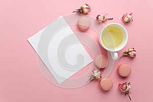 Green tea and pastel french macarons cakes on pink background. Dessert in a garden. Flat lay. Free text space.