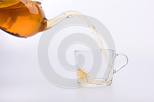 Green tea pouring into glass cup Isolated on white