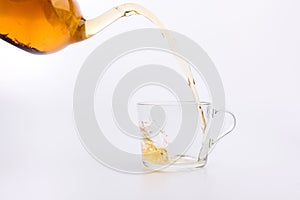 Green tea pouring into glass cup Isolated on white