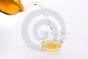 Green tea pouring into glass cup Isolated on white