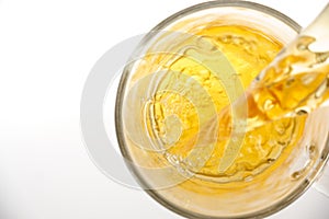 Green tea pouring into glass cup, top view