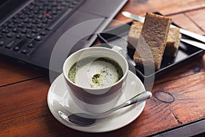 Green tea is served with hot bread between the notebook.