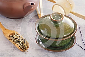 Green tea in a wooden spoon, attributes for a tea ceremony and the traditional Chinese porcelain green cup