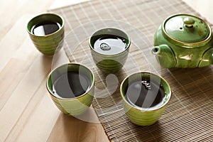 green teapot and teacups. hot drink on wooden table. Organic product from the nature for healt