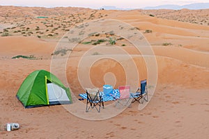 A green tent for family camping in the sand dunes of the United Arab Emirates desert. Family fun, isolated, quiet, arid