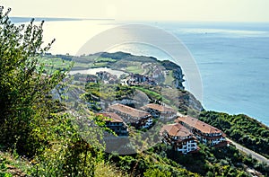 Green Thracian cliffs near blue clear water of Black Sea, hotels